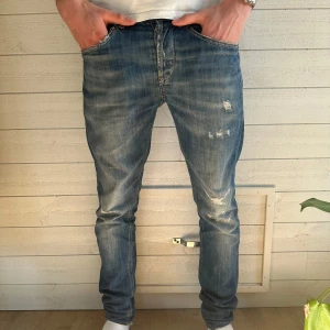 Dondup George jeans - Säljer ett par blå jeans med coola slitningar och en klassisk femficksdesign. De har en normal passform och är perfekta för en avslappnad stil. Jeansen är använda fåtal gånger, och i bra skick. Original pris 2000kr mitt pris 900kr💯