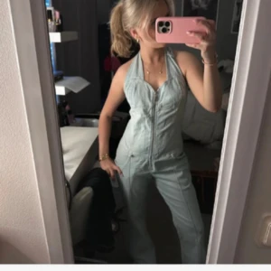 Ljusblå ärmlös jumpsuit - Snygg ljusblå ärmlös jumpsuit med dragkedja framtill. Perfekt för en avslappnad och stilren look. Passar bra till både vardag och festliga tillfällen. Använd fåtal gånger i bra skick 