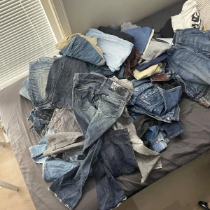 Y2K Jeans bundle pack - 2kg - Här har du chansen att antingen spicea upp din garderob eller köpa billigt bundle pack Y2K jeans - 2kg. Perfekt för dig som som sagt vill spicea upp din garderob eller köpa för att sälja vidare för bra marginaler. Alla jeans är olika storlekar och färger och kommer random. Alla är handutplockade för bästa kvalité och sizing.