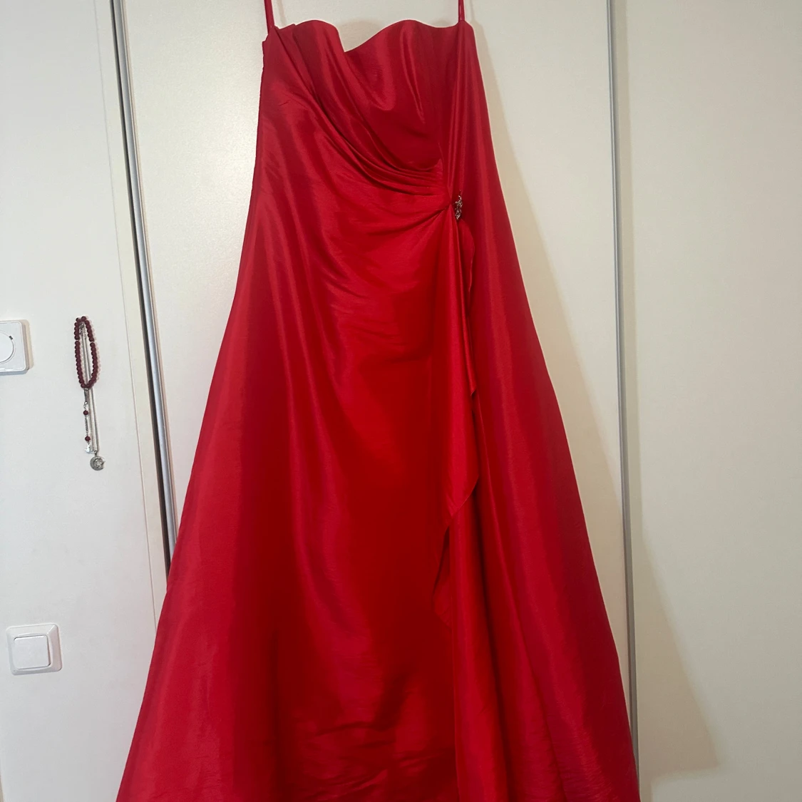 Röd långklänning med dekorativ detalj