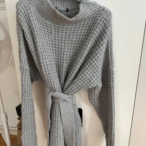 Stickad klänning  - Grå stickad klänning med Knut, slutar på låren. Som ny