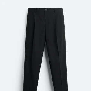 Svarta kostymbyxor - Eleganta svarta kostymbyxor med en klassisk design. Byxorna har en rak passform och är perfekta för en stilren look. De har knappar i midjan och är tillverkade i ett bekvämt material.