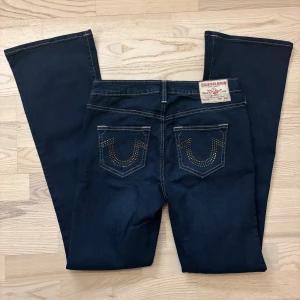 Becca jeans True Religion W27 - Snygga mörkblå bootcut jeans från True Religion med nitar på bakfickorna. Endast provade. Nya utan tag. 