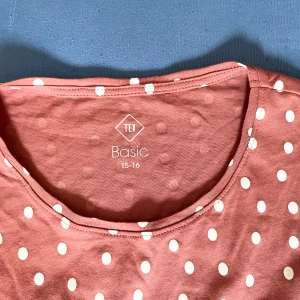 Röd prickig långärmad klänning från Tex - Söt röd klänning med vita prickar från Tex. Klänningen har långa ärmar och en rund halsringning, perfekt för en avslappnad stil. Storlek 15-16.