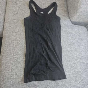 Svart linnetopp från 157 - Säljer en svart linnetopp från 157 i storlek S. Tillverkad av 100% ekologisk bomull, perfekt för en bekväm och stilren look. Linnet har en klassisk design med brottarrygg.