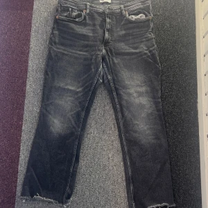 Svarta jeans från Zara - Snygga svarta jeans från Zara med en cool fransig kant vid bensluten. De har en klassisk femficksdesign och en bekväm passform. Perfekta för en avslappnad stil.