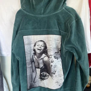 Grön hoodie från Limitato - Snygg grön hoodie från Limitato med ett stort svartvitt fototryck på ryggen. Storlek M. Den är använd men inget slitage. Hör av dig vid frågor eller mer bilder!