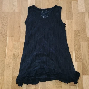 Svart ärmlös klänning från KappAhl - Snygg svart ärmlös tunika från KappAhls Womens Collection. Klänningen har en volangdetalj vid fållen. Köparen står för frakten ✨️