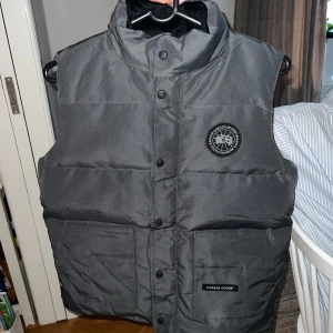 Canada goose vest  - Helt ny Canada goose vest. Fick den i present men tyvärr passa den mig inte. Grå med svart bage. Perfekt till sommaren