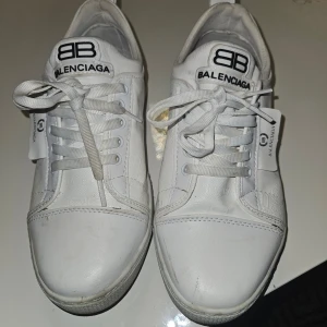 Vita sneakers från Balenciaga - Snygga vita sneakers från Balenciaga med klassisk snörning och logotyp på sidan och tungan. Perfekta för en stilren look.