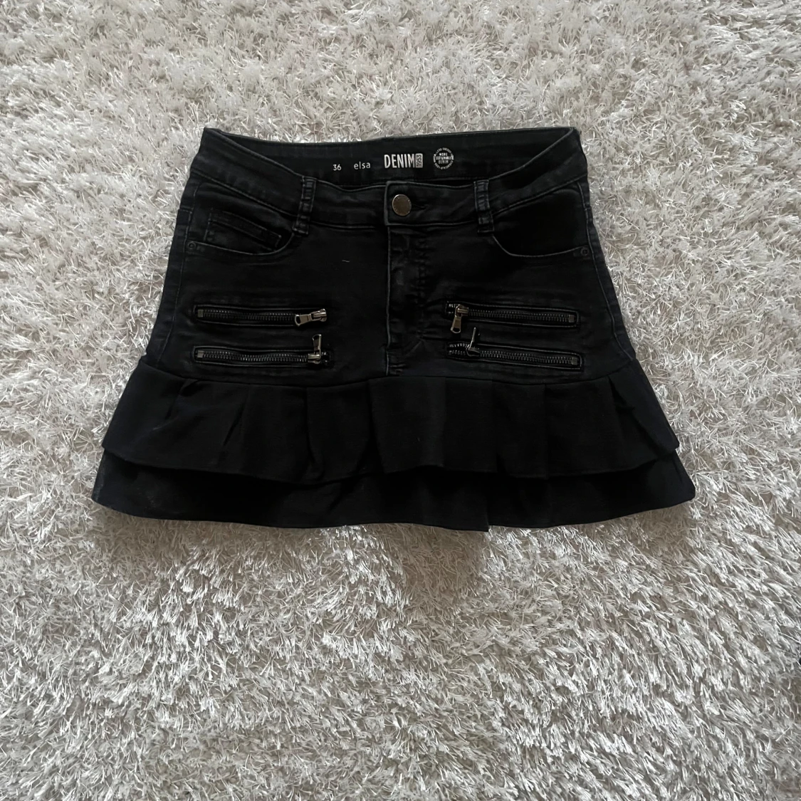 Svart kortkjol med volang och dragkedjor