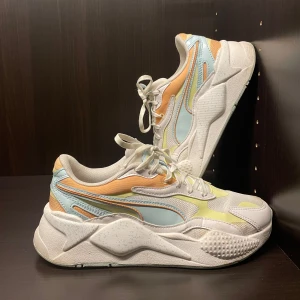 Puma sneakers  - Sneakers med en mix av pastellfärger som blå, gul och orange. Skorna har en chunky vit sula och snörning framtill. Perfekta till våren 