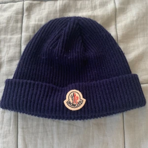 Moncler mössa - Moncler mössa blå bra sick skönt att ha. Använt några gånger   Inte riktig 