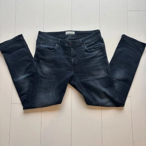 Mörkblå jeans från Stock & Hank - Snygga mörkblå jeans från Stock & Hank med en klassisk femficksdesign. De har en dragkedja och knapp framtill. Perfekta för en avslappnad stil. Det finns en liten skada baktill som visas på bilden. 