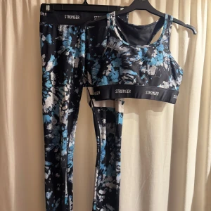 Mönstrad träningsset från Stronger - Snyggt träningsset från Stronger med fint motiv. Setet består av en sport-bh och matchande tights, båda med elastisk kant med logotyp. Sparsamt använt och inga defekter, säljer då de inte kommer till användning🫶🏻