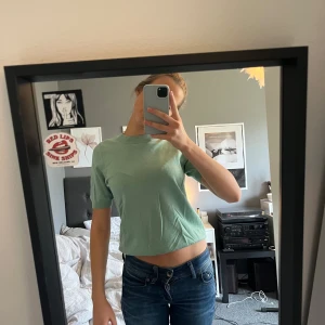 Grön kortärmad topp - Säljer en stilren grön topp med korta ärmar. Perfekt till vardags. Den är knappt använd och är därför i mycket fint skick! (Säljer en likadan beige i min profil!)