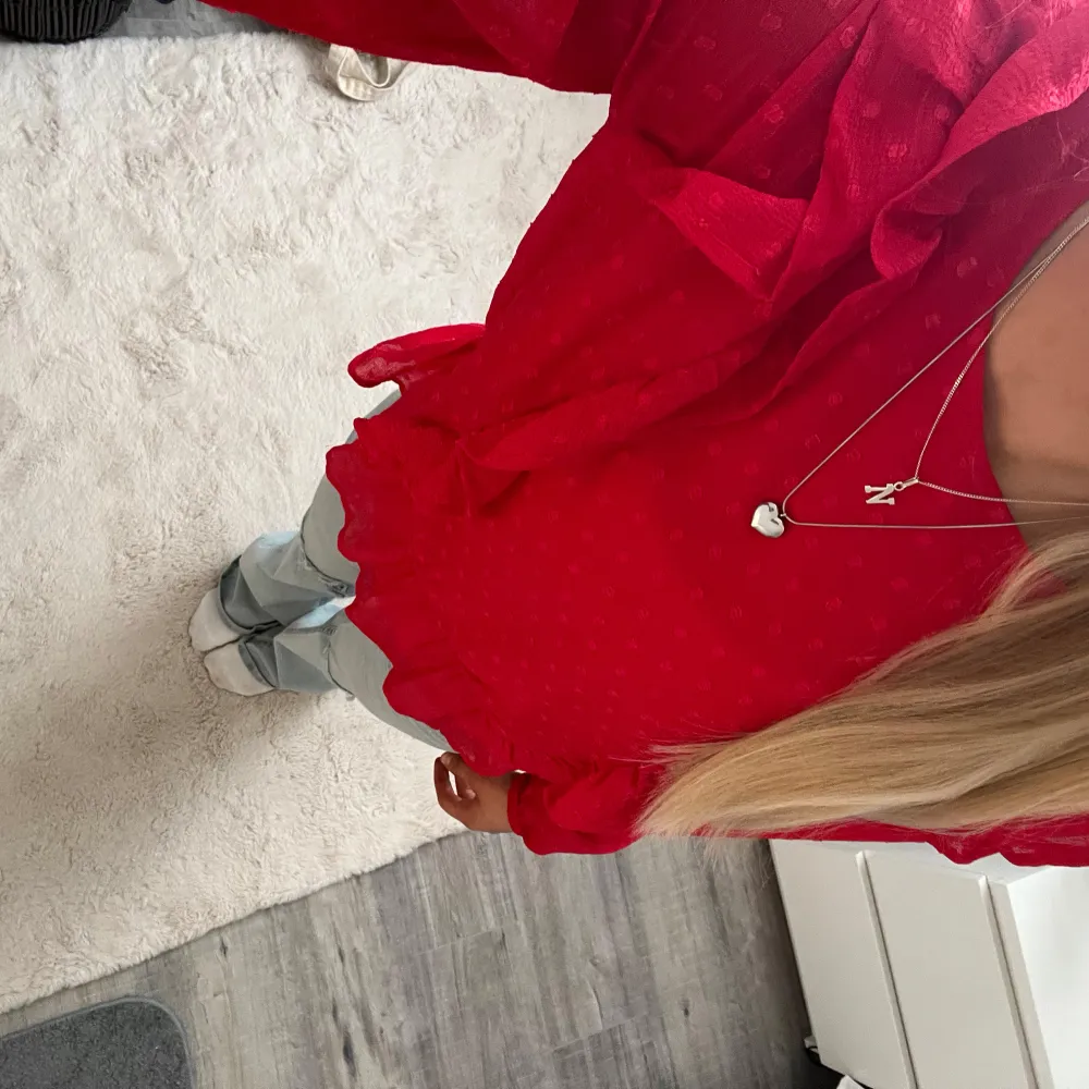Säljer en snygg röd blus med volanger. Blusen har långa ärmar och en elastisk nederkant som ger en fin passform. Perfekt för att piffa upp garderoben med lite färg! Tröjan kommer från Lindex och är i storlek 158, men skulle säga snarare xs. Endast använt en gång under jul💞. Yläosat.