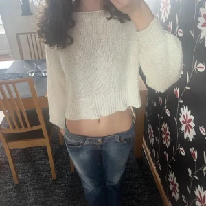 Vit stickad tröja - Säljer en vit stickad tröja som är lite tunnare med croppad passform. Tröjan har långa ärmar och en ribbad nederkant. Perfekt för en avslappnad stil💗