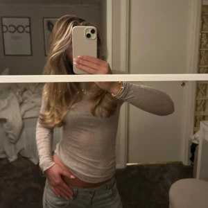 Beige långärmad topp - Säljer en stilren beige långärmad topp med en tight passform från intimissmi. Perfekt för en minimalistisk look och kan enkelt matchas med olika outfits. Toppen är gjord i ett mjukt och bekvämt material. Använd max 4 gånger.