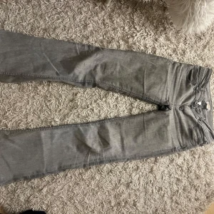 Jeans bootcut lowwaist - Lågmidjade ljus grå jeans från Gina, säljs inte längre, super fint skick, lite urtvättade vid rumpan, har blivit lite buklig men går nog att stryka ner, även en rispa som jag sytt igen. Annars super fina. Stl 164, passar mig som är 168 o brukar ha S