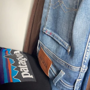 Blå jeans från Replay - Snygga blå jeans från Replay med en klassisk femficksdesign och slitna detaljer. Jeansen har en normal passform och är perfekta för en avslappnad stil. De har en läderpatch med Replay-loggan på baksidan.