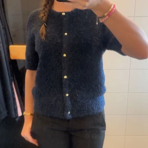 Mörkblå kofta med knappar - Säljer en mysig mörkblå kofta med korta ärmar och fina knappar framtill. Perfekt för en stilren look. Passar bra till både jeans och kjol. Aldrig använd o lappen är kvar.