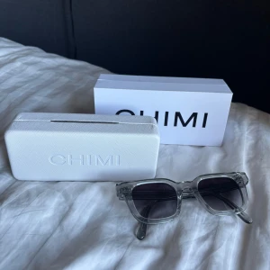 Gråa solglasögon från Chimi - Snygga gråa solglasögon från Chimi perfekta inför sommaren i modell 04. I princip aldrig använda och vill sälja därför dom inte kommer till användning. Kommer med ett vitt fodral och originalförpackning.💕💕