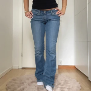 Blå bootcut jeans - Snygga blå bootcut jeans med låg midja. Perfekta för en avslappnad stil. Jeansen är ifrån Levis! Midjemåttet är cirka 37cm och innebenslängden är 83cm!😊
