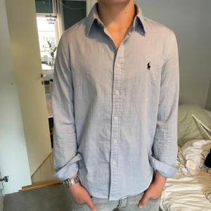 Ljusblå skjorta från Ralph Lauren - Säljer en snygg ljusblå skjorta från Ralph Lauren. Skortan är i princip helt ny. Skick: 9/10. Nypris cirka 1700kr. Mitt pris 559kr🔥🔥pris kan diskuteras. kolla gärna in min profil och följ mig så ni inte missar alla bra erbjudan!!