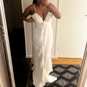 Vit långklänning med volang och v-ringning - Superfin elegant vit långklänning!! Med smala axelband, djup v-ringning och markerad midja. Oanvänd från Bella barnett. 🤍🤍