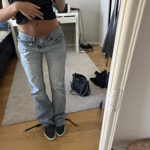 Ljusblå lågmidjade jeans  - Säljer ett par ljusblå jeans från Vila. De är lågmidjade och har en straight passform. Midjemått: 37cm rakt över, Innerbenslängd: 84cm💕de är slitna längst ner på benen och lappen på baksidan men annars fint skick❤️skriv vid funderingar 