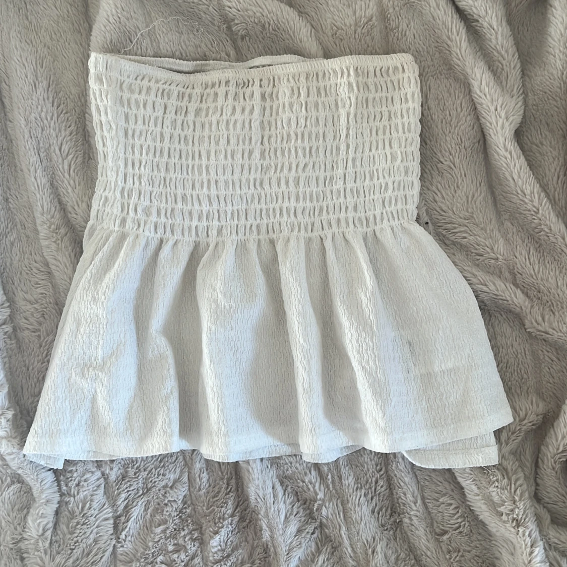 Vit smockad volang  tubtopp från Gina Tricot