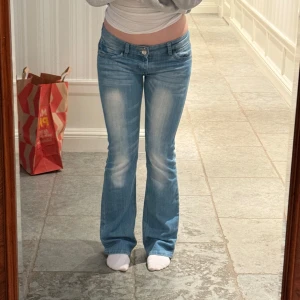 Ljusblå bootcut jeans - Säljer ett par ljusblå lågmidjade bootcut jeans🩵 superfina detaljer!! Midjemått rakt över är 38cm, innerbenslängd 82cm⚡️Priset är såklart diskuterbart. Jag är 164💕