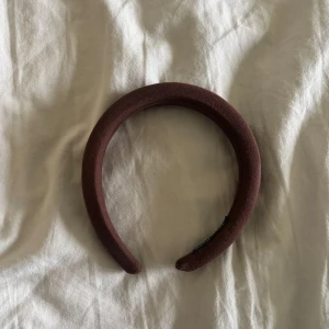 Brunt vadderat diadem - Snyggt och trendigt brunt diadem med vadderad design. Perfekt accessoar för att lyfta din look och hålla håret på plats. Diademet har en mjuk och bekväm passform och är klätt i ett tygmaterial.