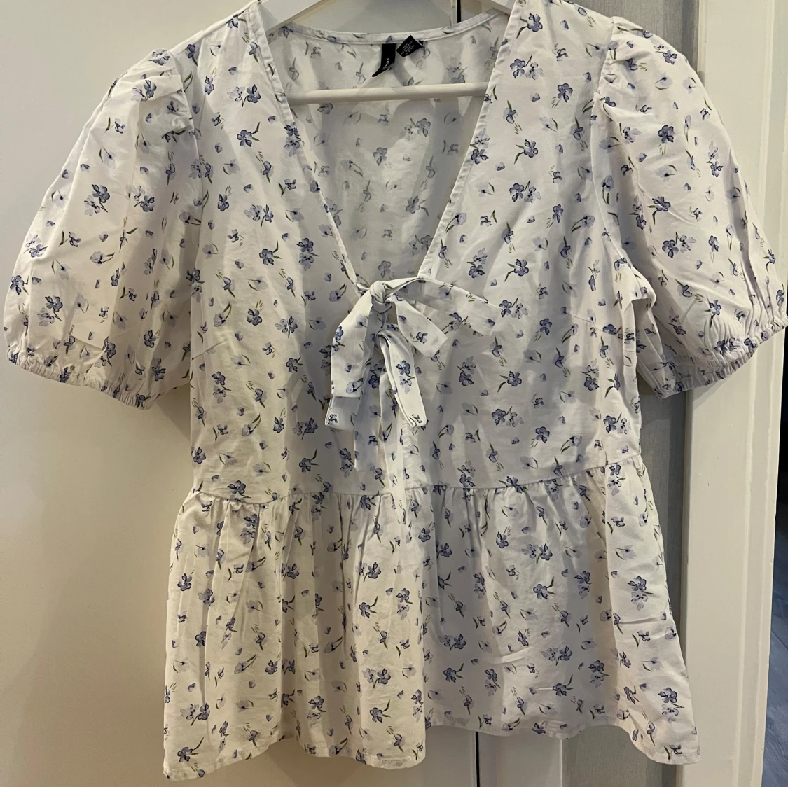 Vit blommig blus med knyt fram