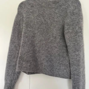 Grå mohair/ull tröja - Supermjuk och fluffig grå tröja från H&M premium i mohair- och ullblandning. Tröjan är relativt tjock, har en rak passform, ribbad hals och långa ärmar. Perfekt till sena lite kyliga sommarkvällar eller bara för att helt enkelt tjuvstarta höstgarderoben! Jag säljer den då jag redan har för många gråa tröjor och den blir  tyvärr bara hängandes i garderoben. Tröjan är i storlek M men passar bra på mig som normalt har XS/S. Nypris är ca 1000 kr