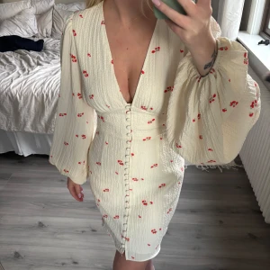 Adoore klänning strl 38 - Supersöt adoore klänning med små röda blommor, djup v-ringning och markerad midja. Storlek 38, endast använd 1 gång ❣️