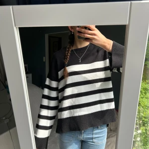 Stickad tröja Gina Tricot  - Säljer en vit randig stickad tröja från Gina Tricot Young. Tröjan har breda ränder, ribbade muddar och rund hals. Perfekt för dig som gillar en chill och avslappnad stil. Passar till både jeans och kjol. Storlek 158-164, men passar S