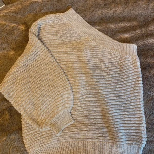 Glittrig beige stickad tröja MNG - Superfin stickad tröja från MNG i beige med guldglittriga trådar. Tröjan har lång ärm, ribbade muddar och en loose passform. Perfekt för dig som vill ha något mysigt men ändå lite extra. Snygg till både jeans och kjol!