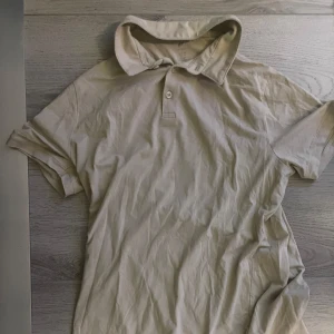 Beige pikétröja - Snygg beige pikétröja från H&M i slim fit-modell. Perfekt för dig som vill se riktigt fräsch ut nu inför sommar. Tröjan är använd fåtal gånger och är i bra skick. Pris kan såklart diskuteras😁
