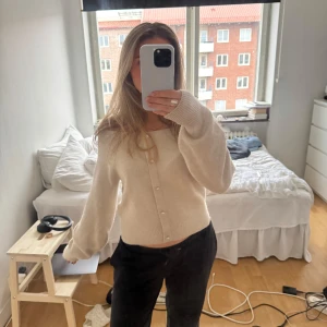 Ljus offshouldertröja från H&M  - Superfin beige stickad tröja från H&M med snygga knappar framtill, ej äkta utan endast för dekoration. Mjuk och skön, perfekt till sommarkvällar eller till hösten. Kan välja själv om man vill ha den off shoulder eller ”vanligt”, jättebra skick!