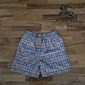 Burberry Shorts - Letar du efter lyxiga badshorts med stil? Dessa helt nya Burberry-shorts i klassiska rutor kombinerar sofistikerad design med hög komfort. Tillverkade i kvalitativ bomull med mesh-innershorts och elastisk midja för perfekt passform. Originaletikett "BURBERRY London England" kvar. Perfekta för strand, pool eller semester!  Storlek: S | Skick: Nya med taggar | 📦 Snabb leverans!  Hör av dig vid intresse! #burberry #herrmode #lyxstil #sommarlook  
