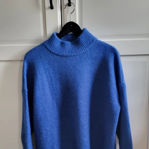 Blå stickad polotröja från Indiska - Mysig blå stickad polotröja från Indiska i storlek M. Tröjan har en hög ribbad krage och långa ärmar med breda ribbade muddar. Endast provad. Hör av dig med frågor, är öppen för prisförslag 🌸