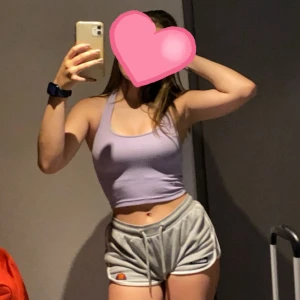 Ljuslila ribbad linnetopp - Säljer en ljuslila croppad linnetopp med ribbad struktur. Toppen är ärmlös med breda axelband och har en snygg, tight passform. Perfekt till jeans eller shorts för en chill och trendig look.