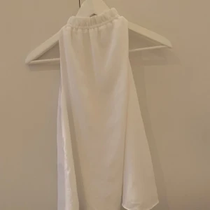 Vit linnetopp😇 - Supersnygg vit ärmlös linnetopp från H&M med knytning i nacken. Tunt och luftigt material som ger en clean och fräsch look. Perfekt för varma dagar🤍