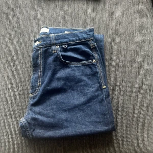 Mörkblå jeans från MNG - Snygga mörkblå jeans från MNG med klassisk femficksmodell och kontrastsömmar. Jeansen har normal passform och raka ben, tillverkade i mjukt denimtyg. Perfekta för en stilren och enkel look till sommar.