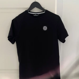 Svart t-shirt från Stone Island - Svart t-shirt från Stone Island med klassisk rund hals och ikonisk logopatch på bröstet.                           Storlek M, men sitter mer som S.                                   Helt ny!