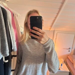 Grå stickad tröja från H&M - Säljer en mysig grå stickad tröja från H&M. Tröjan har en klassisk design med långa ärmar och ribbade muddar vid ärmslut och nederkant. Perfekt för kyliga dagar. Hör av dig vid intresse! 💞