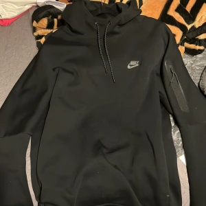 Svarta mjukisbyxor och matchande tröja från Nike - Säljer ett par svarta mjukisbyxor och tröja från Nike med dragsko i midjan och praktiska fickor med dragkedja på byxorna. Perfekta för en avslappnad stil eller träning. Byxorna har en diskret Nike logo på sidan. De är knappt använda och är i mycket bra skick. Kan säljas separat. Passar m också.