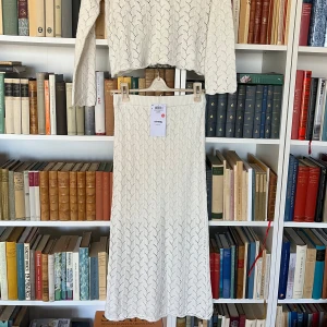 Vitt stickad set med maxikjol och tröja - Säljer en vit stickad tröja och en lågmidjad kjol från Sinsay med ett vackert mönster🤍 Tröjan har långa ärmar och en knytning vid halsen och kjolen har elastisk midjeband Perfekt för sommaren , studenten eller stranden ☀️ Aldrig använda! 